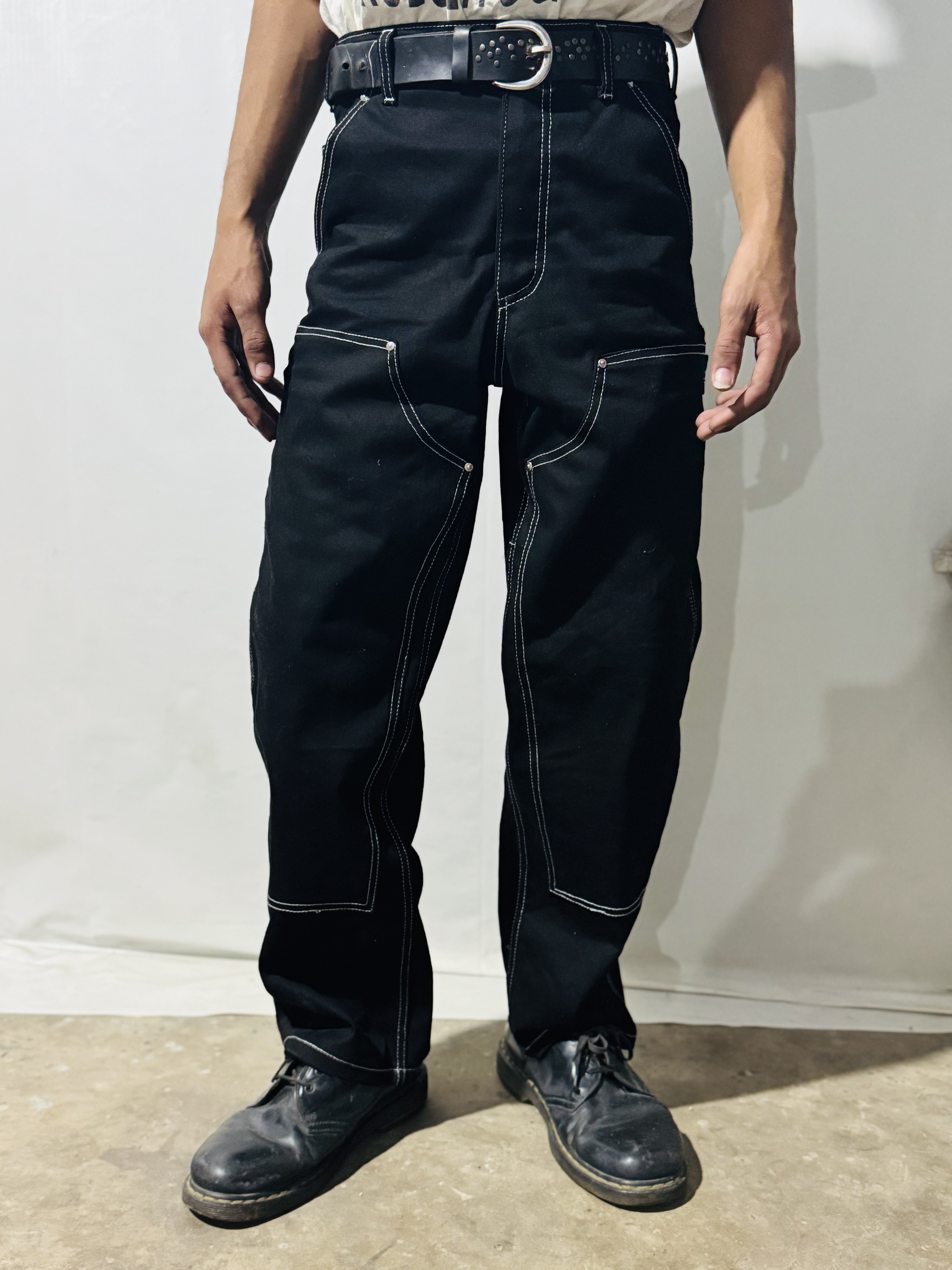 Pantalon en denim noir Carhartt à double genoux avec coutures blanches de style rework.