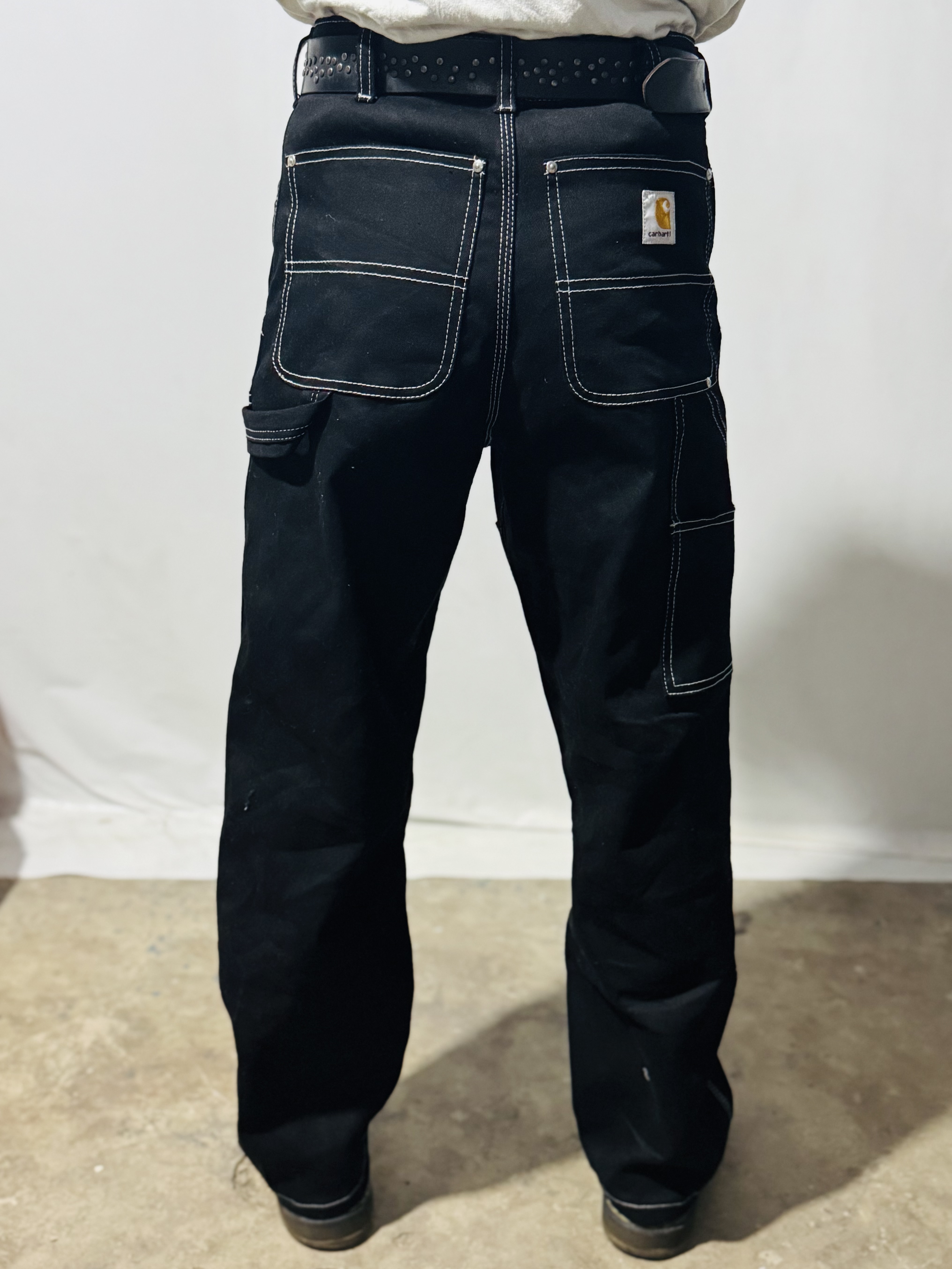 Pantalon en denim noir Carhartt à double genoux avec coutures blanches de style rework.