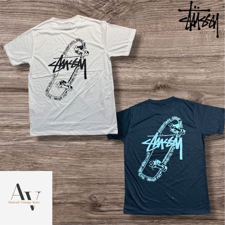 T-shirts de style rework Stussy en pose de skateboard.